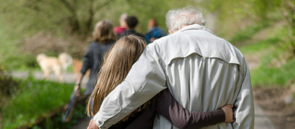 Eine junge und eine ältere Person laufen Arm in Arm